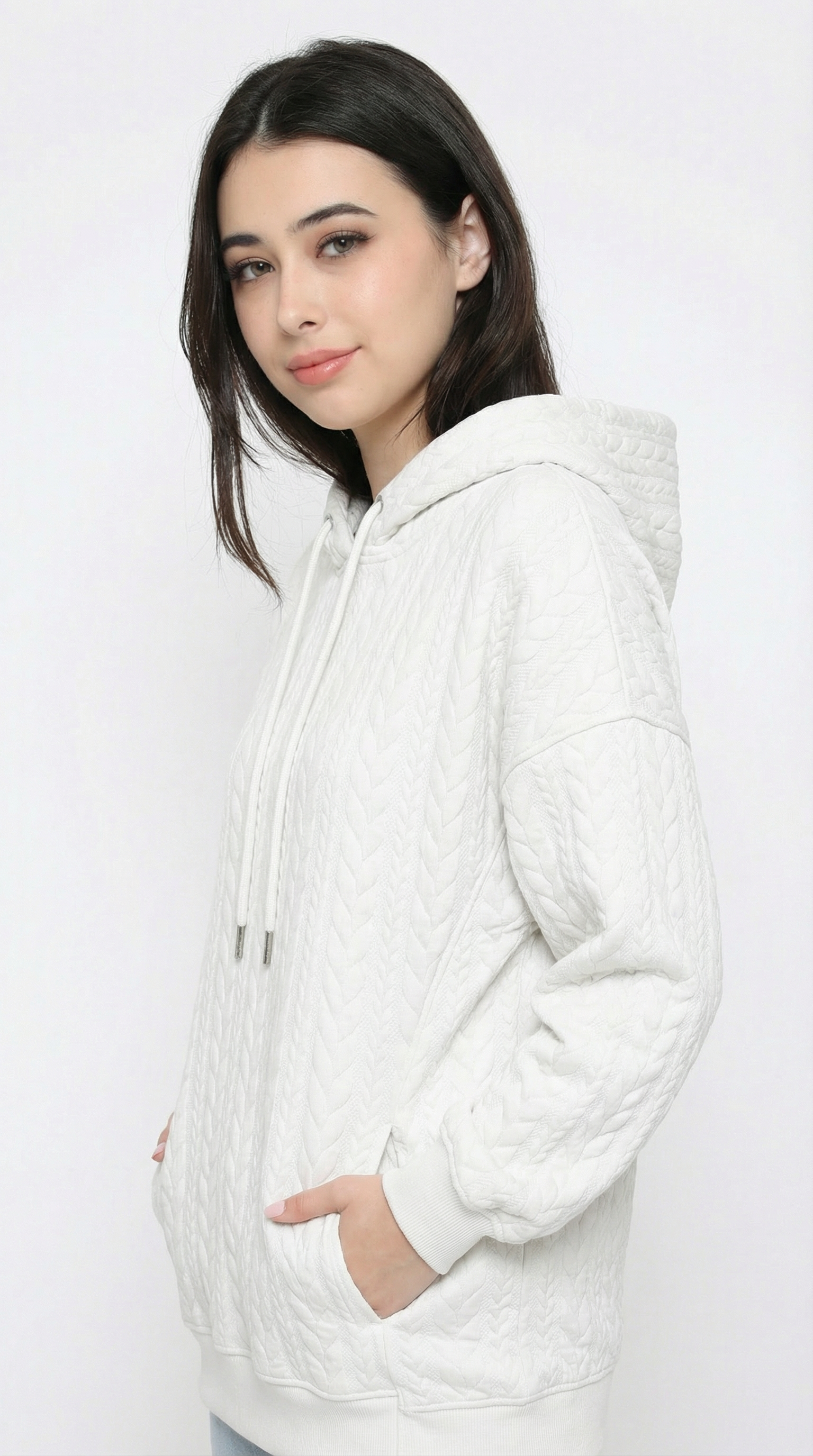 Woman wearing a white hoodie against a plain background