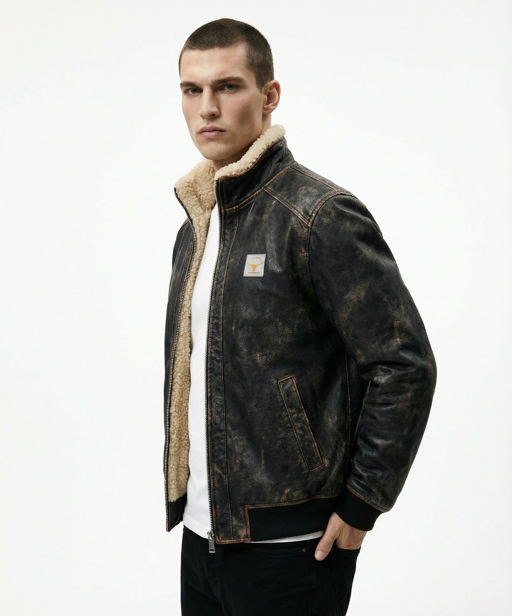 Man wearing a dark denim jacket with a shearling collar on a white background