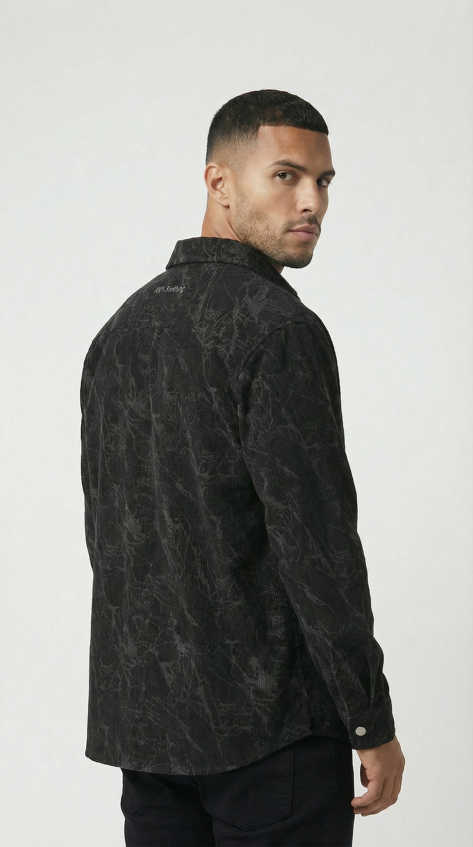 Man wearing a black patterned shirt against a white background