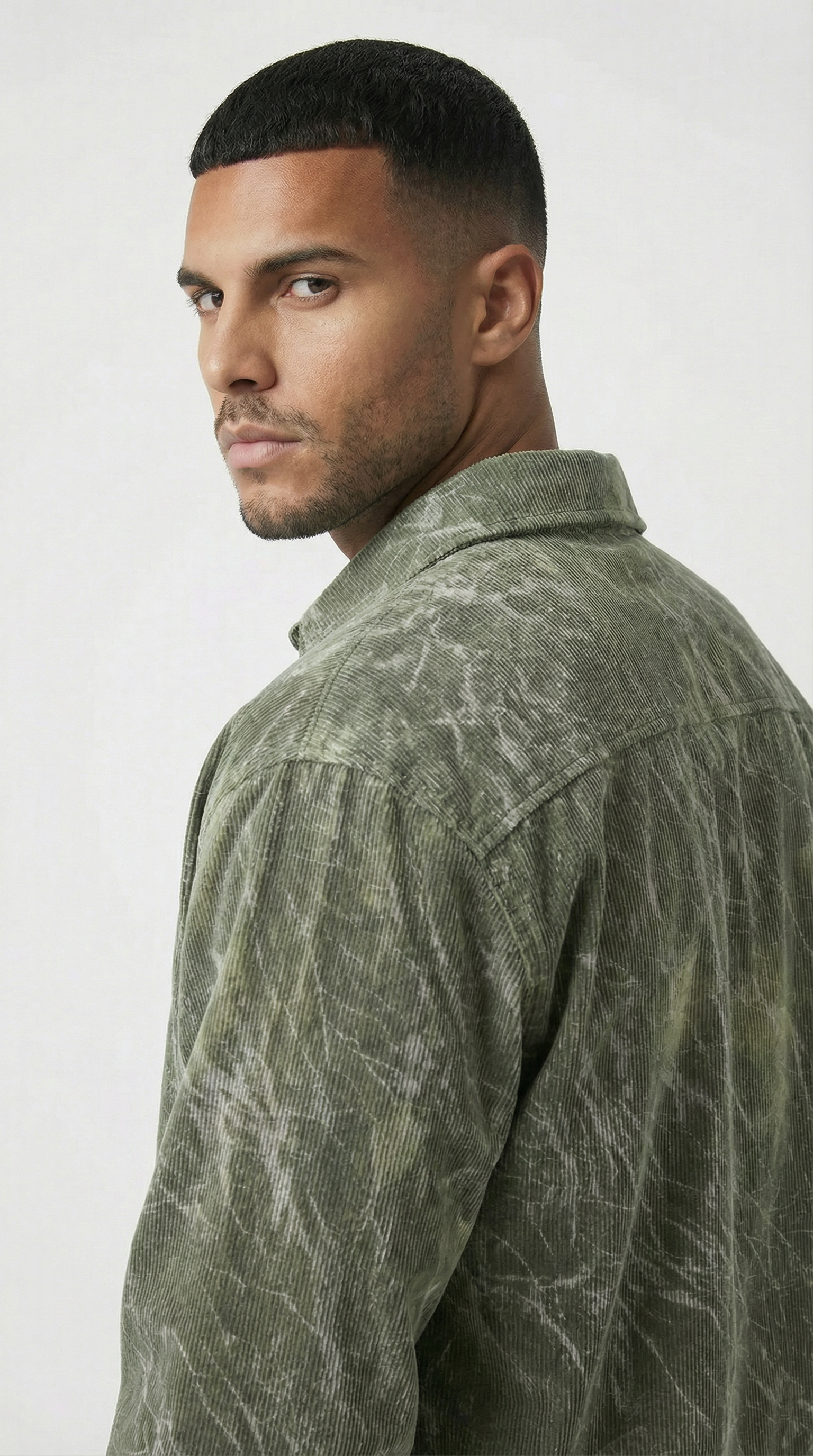 Man wearing a green patterned shirt against a white background