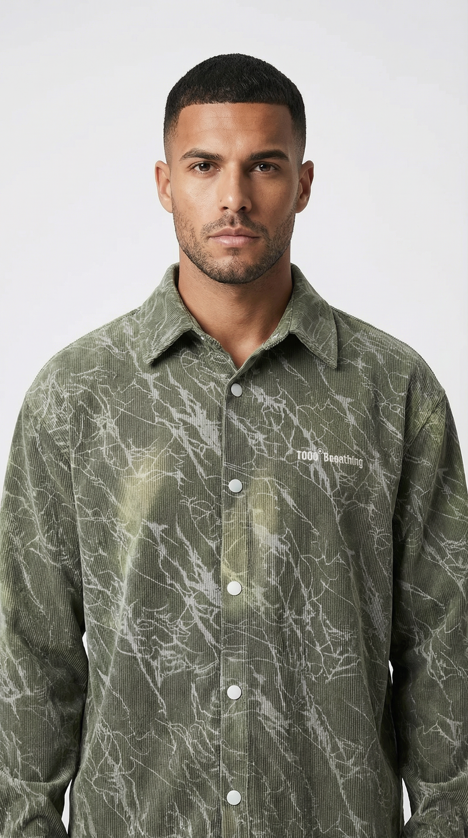 Man wearing a green patterned shirt against a white background