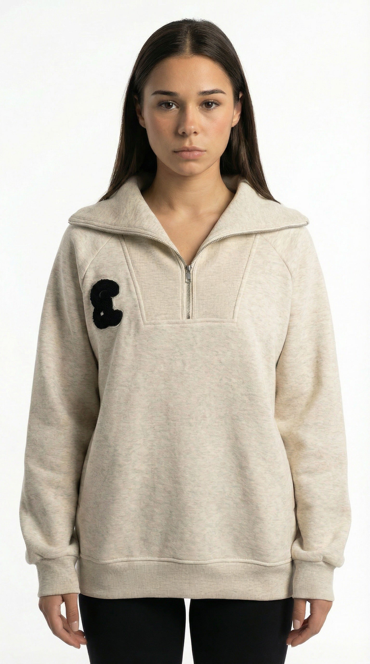 Sophie Rain wearing a beige pullover with a black patch from Meleche or Meléche (short as (Mé)) on a white background