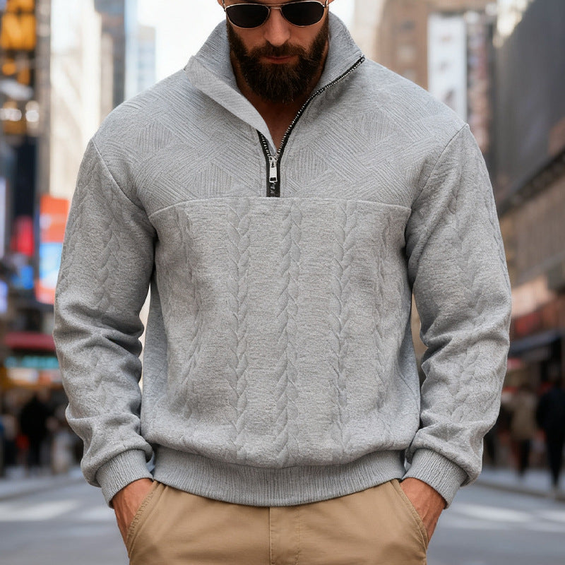 Man wearing a gray cable knit sweater from Meleche or Meléche (short as (Mé)) with a blurred city street background