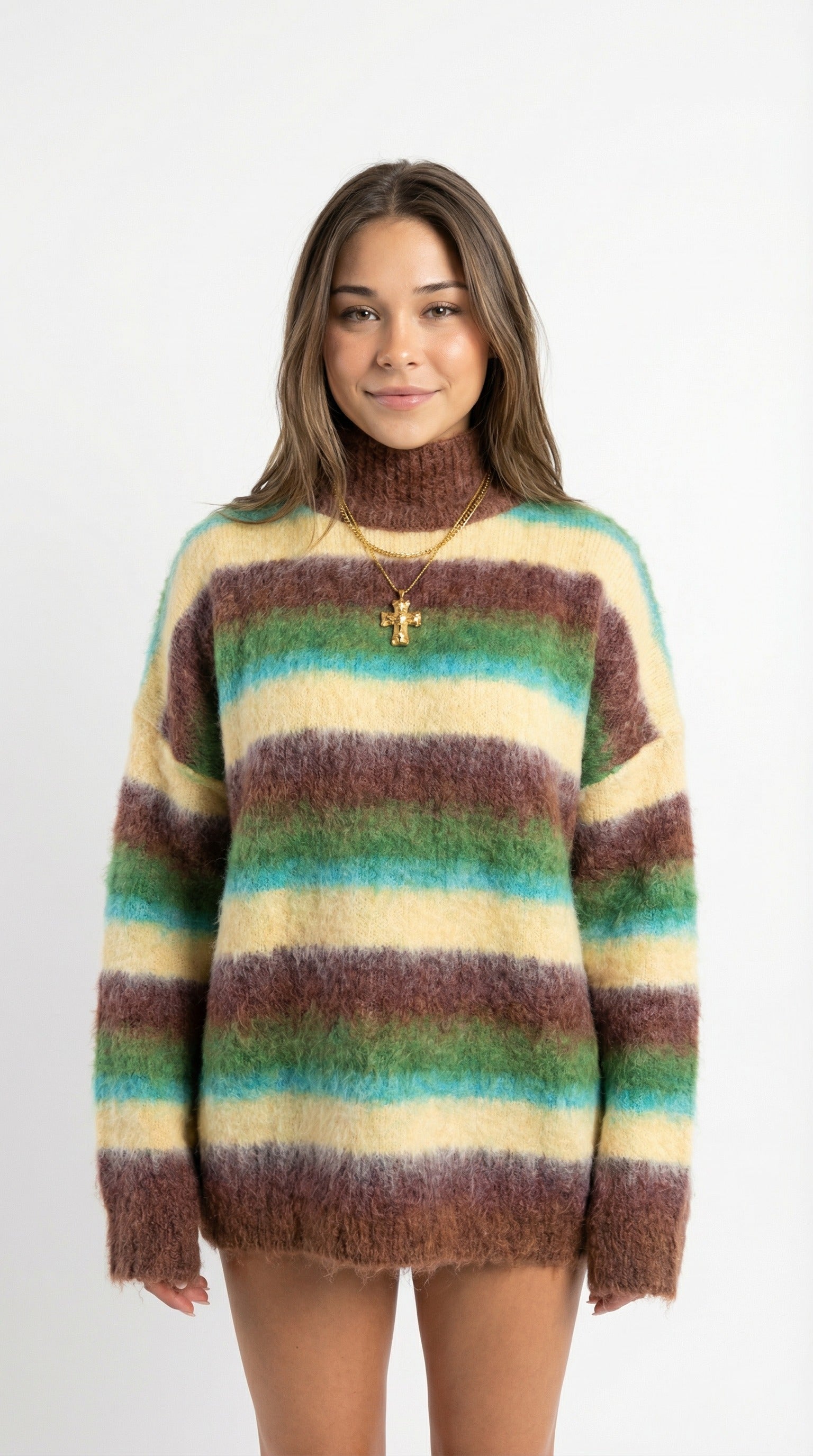 Woman wearing a colorful striped sweater and leopard print skirt standing against a white wall.