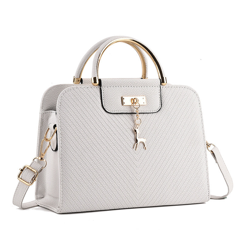 White handbag with gold accents on a white background